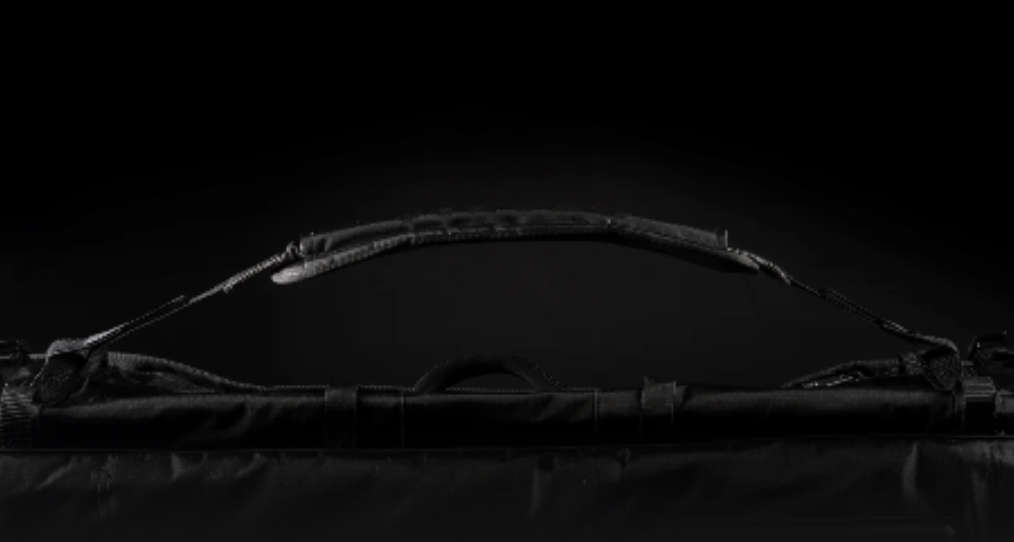 Side view of a long black board bag lit against a dark studio background