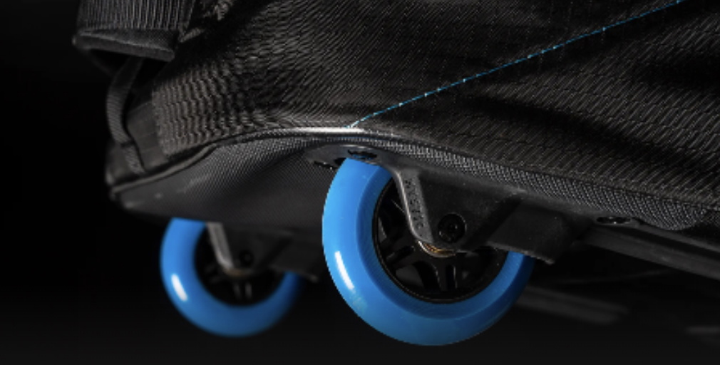 Close-up of two blue wheels on the base of a wheeled black board bag