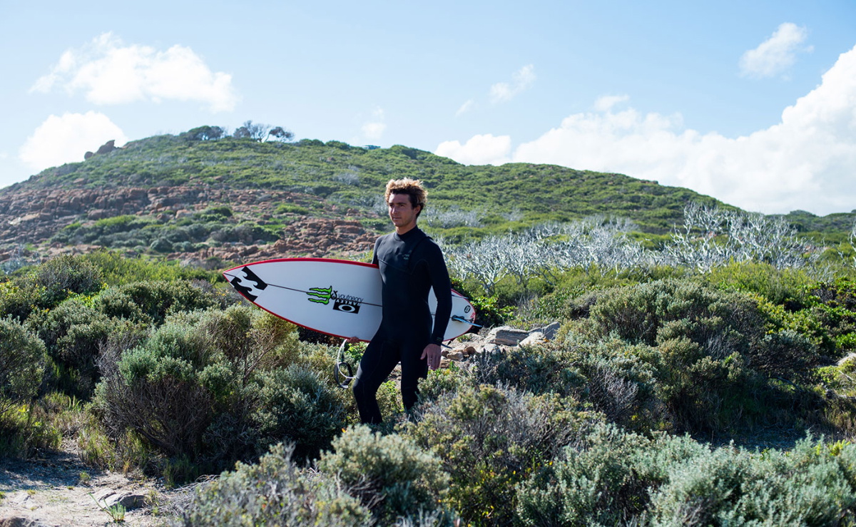 Surfeur en combinaison eco fabriquée avec des matériaux recyclés et sans néoprène