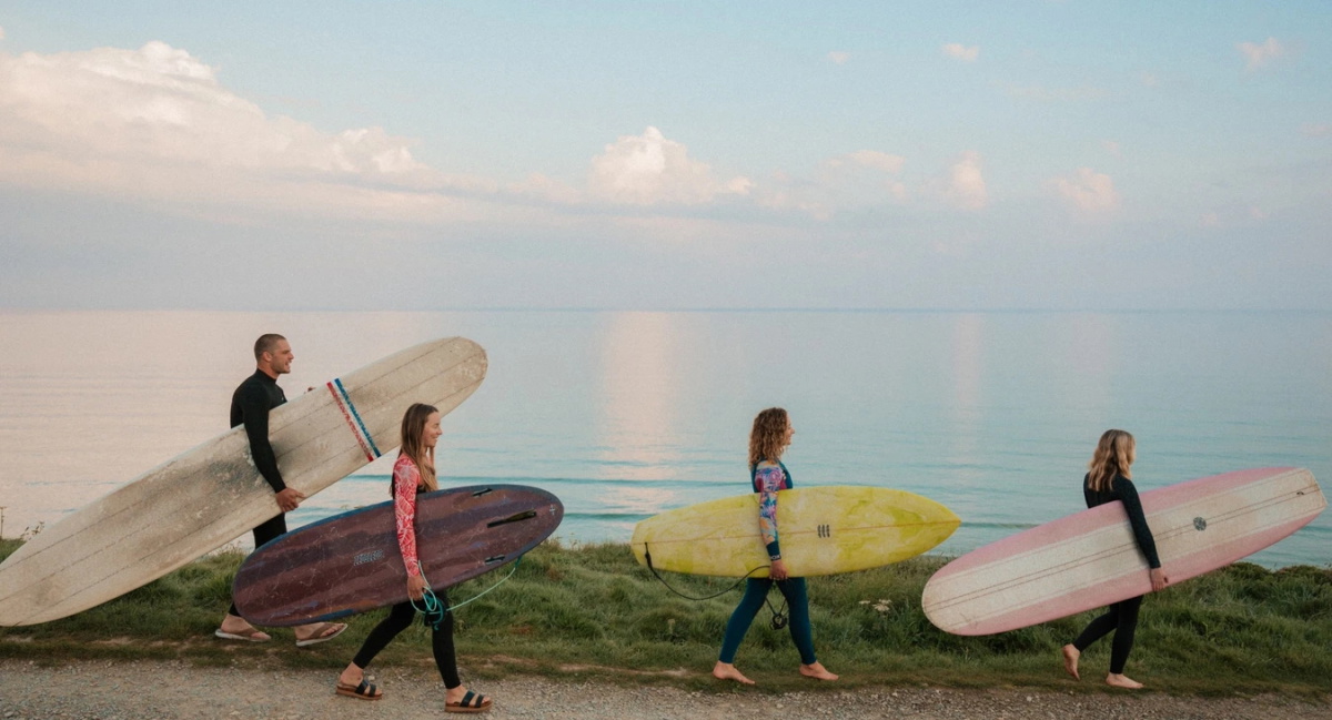 Surfeurs en combinaison d'été rejoignant l'eau