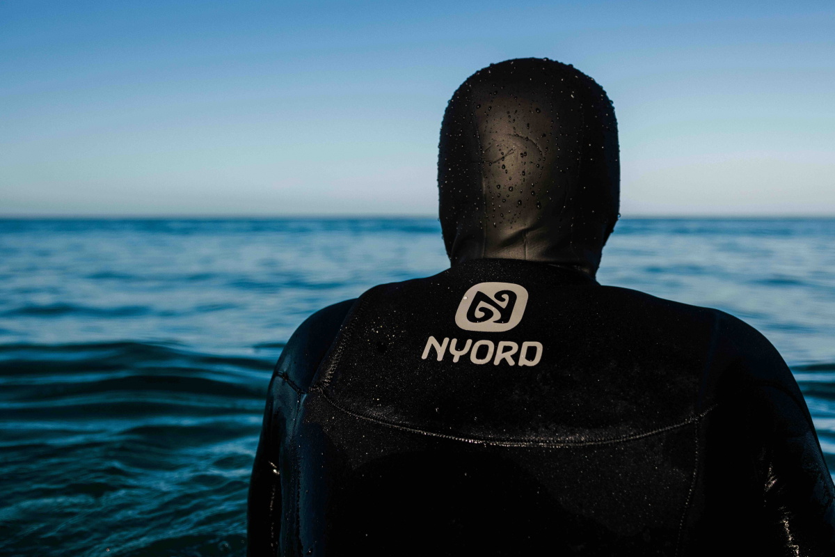 Surfeur en combinaison Nyord sur la plage