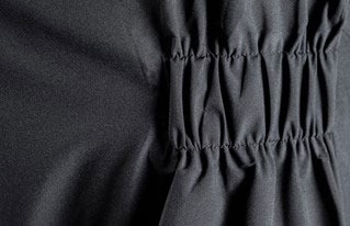 Close-up of the elasticated gathered waistband on dark grey technical sailing trousers