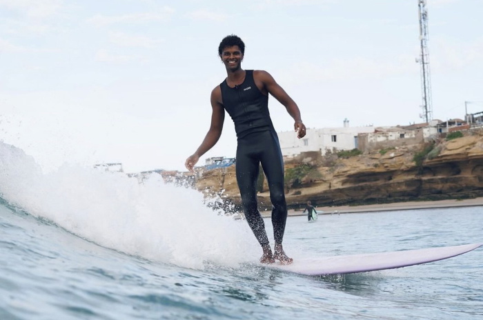 Surfeuse en combinaison sans manches Nyord Solu Long Jane sur une plage en été