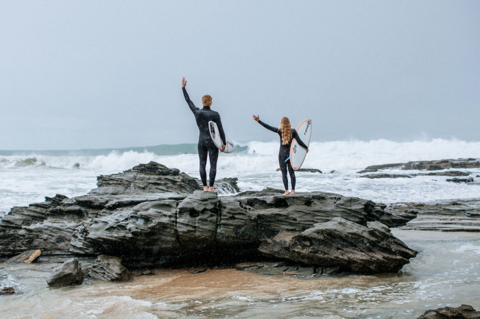Surfeur en combinaison Rip Curl Trad rejoignant les vagues avec sa planche